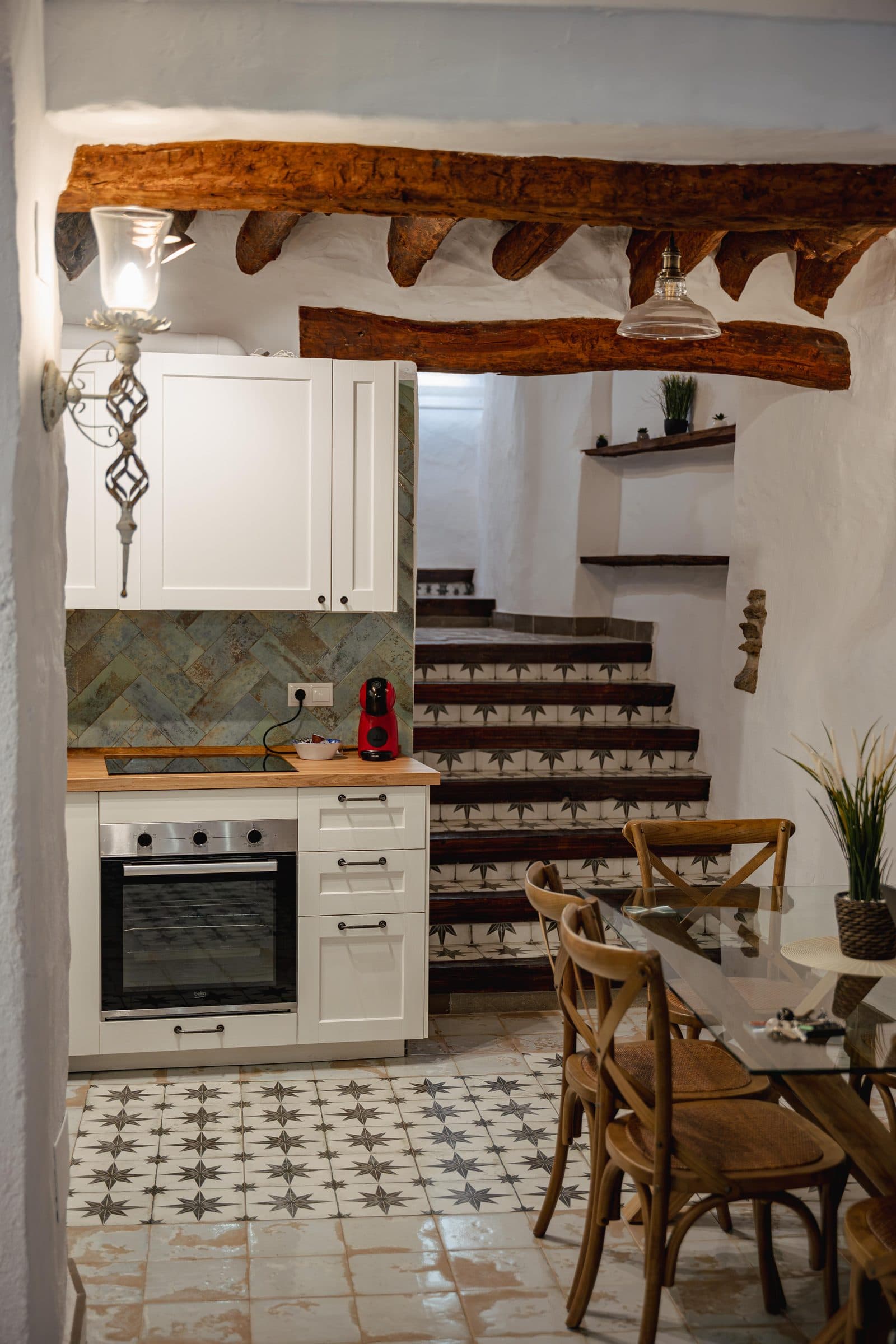 Cocina y comedor bajo vigas de madera, sobre suelo hidráulico, en Casa Cuadra, en Albondón