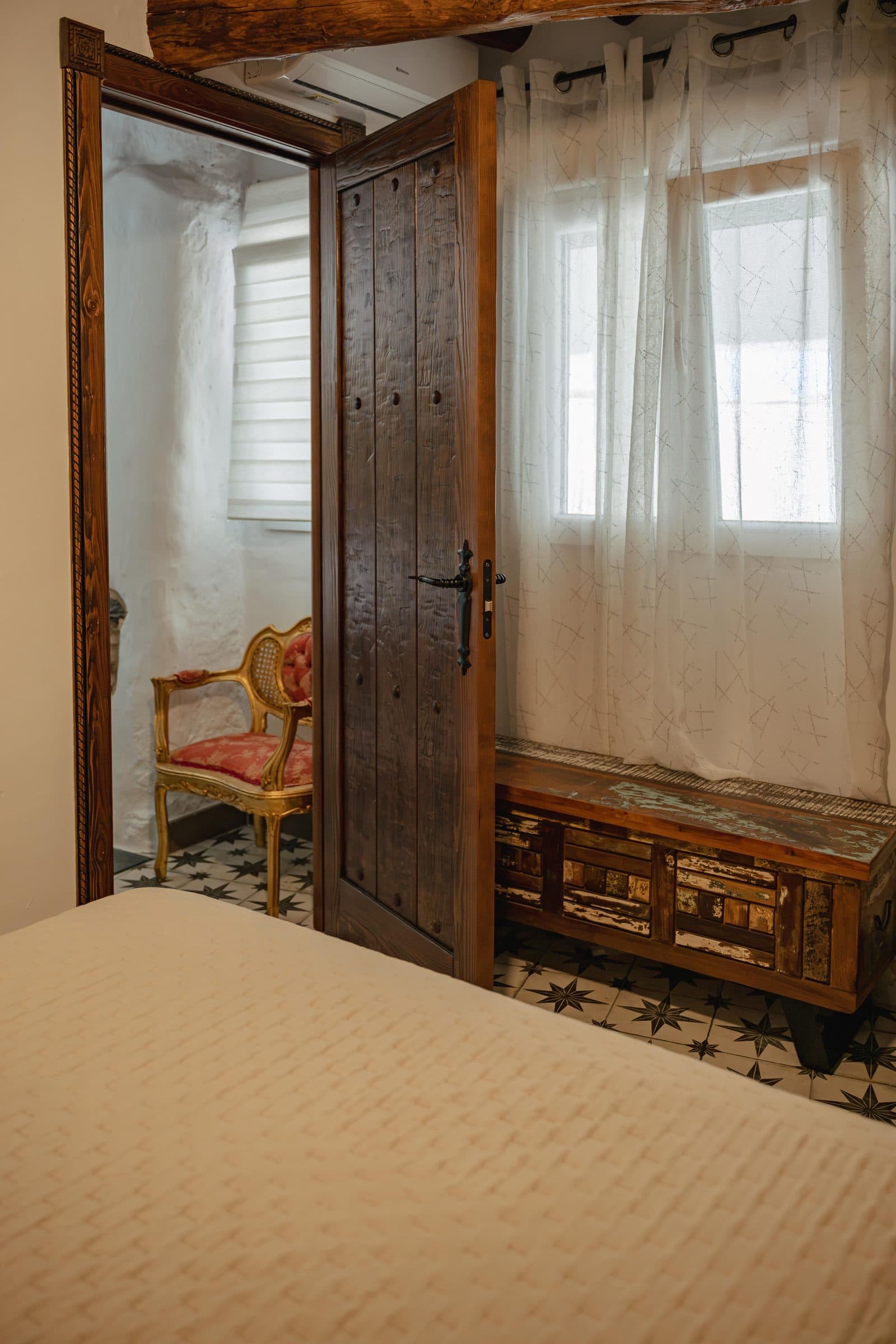 Puerta de madera antigua y arcón en el dormitorio de Casa Cuadra, en Albondón