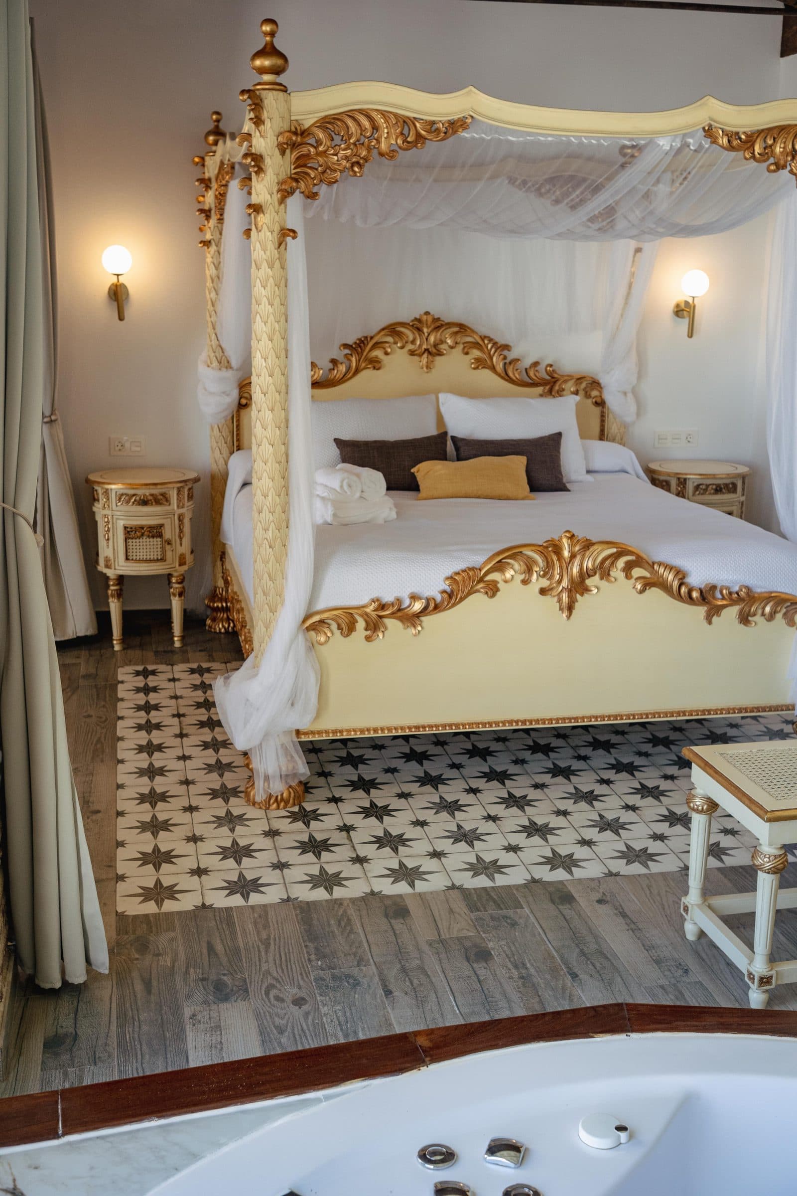 Suite con cama de dosel dorado y jacuzzi en la propia habitación, en la Casa Museo del Trovo y Aguardiente de Murtas
