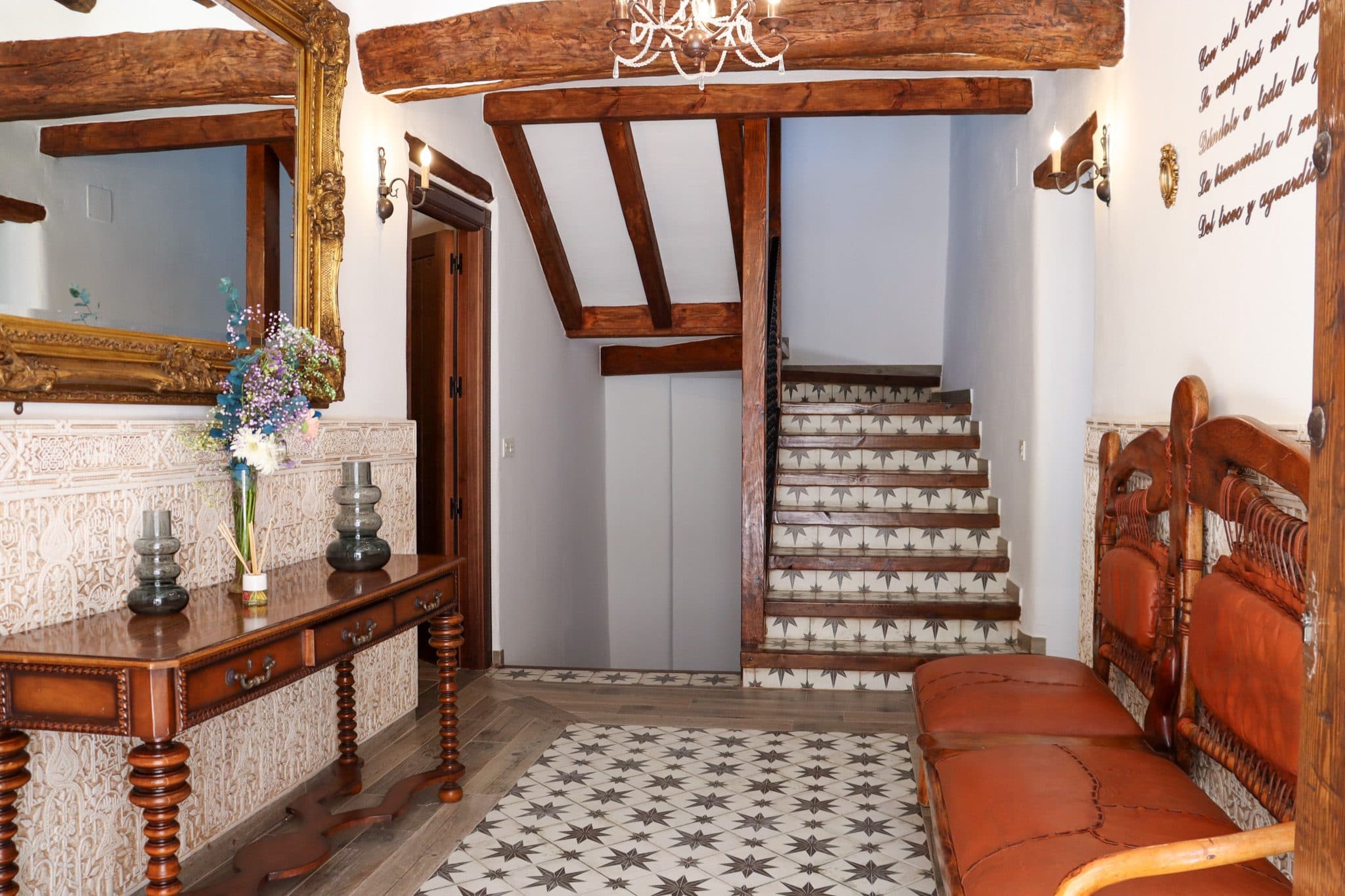 Zaguán con consola de mármol, espejo dorado y escalera con peldaños de azulejo, en la Casa Museo del Trovo y Aguardiente de Murtas